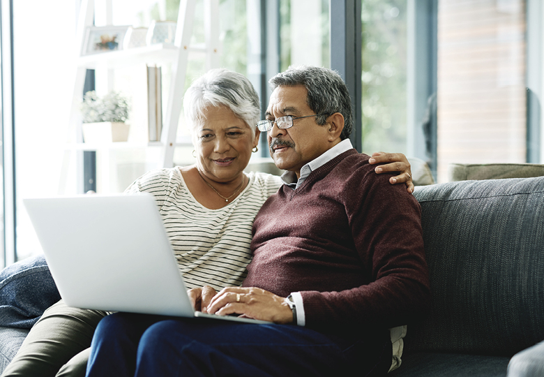 older couple on sofa looking at laptop