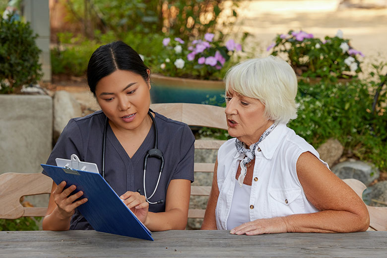 clinician looking at clipboard with patient
