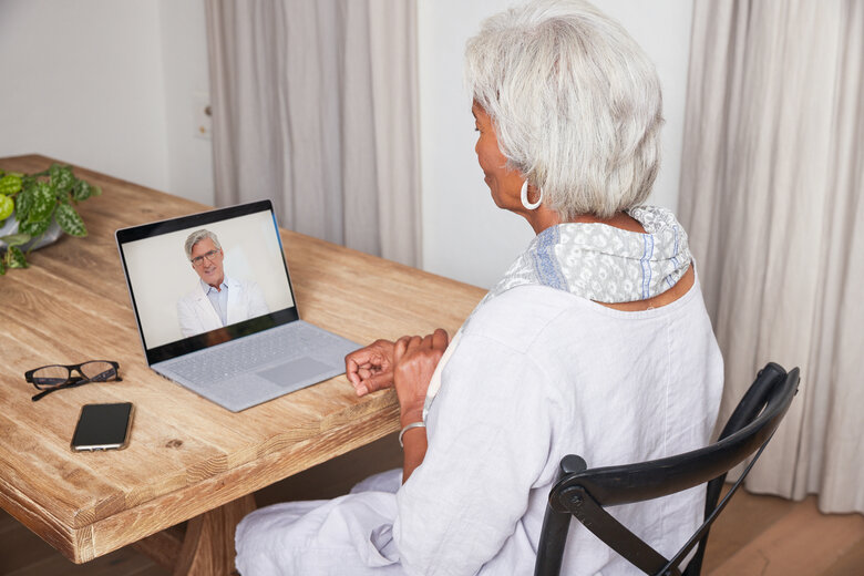 Telehealth Black Older Female Dining Room on Laptop with Doctor